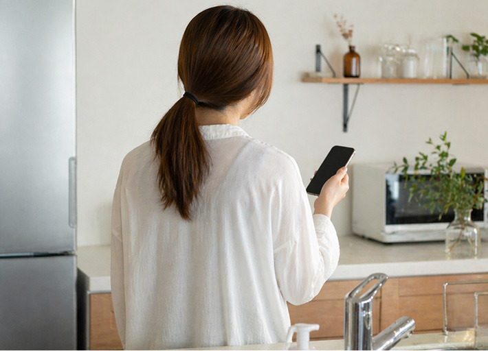 スマホをいじる女性の画像